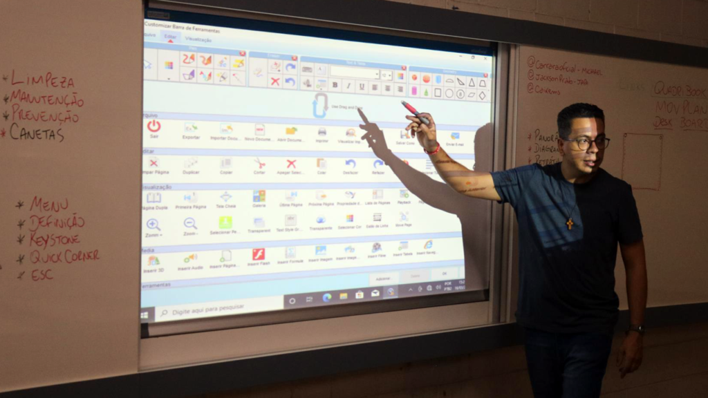 Professor em sala de aula usando lousa digital interativa
